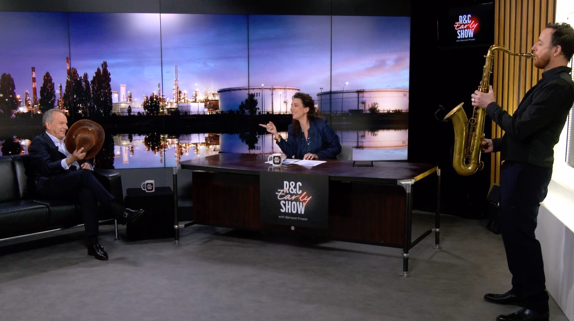 Plateau de tournage talk-show « R&C Early Show » avec animatrice au desk, invité en fauteuil et saxophoniste en direct, devant un mur LED — Studio Webcast Paris.